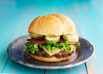 hamburger with pickles on retro rustic painted wood planks