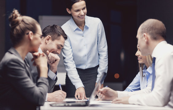 smiling female boss talking to business team