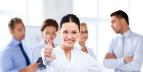businesswoman in office showing thumbs up