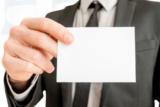 Closeup of businessman showing blank white business card