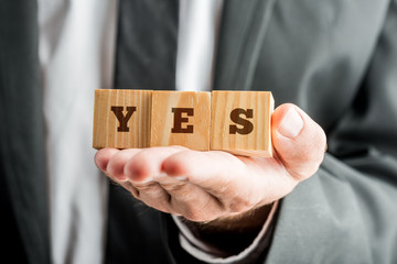 Businessman Showing Wooden Cubes with YES Word