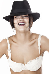 Beautiful woman wearing bra and hat and laughing