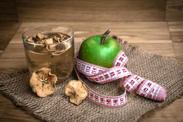 Apple juice with apples on wooden background