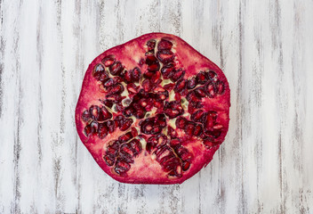 Pomegranate section overhead view on a white wooden kitchen table