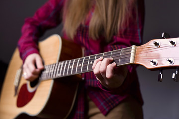 woman's hands playing acoustic guitar, close up, finger position