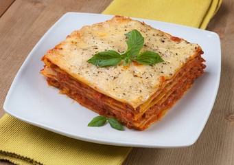Tasty flavorful lasagna on a plate and ingredients