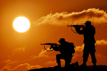 Silhouette of soldier officer with weapons at sunset