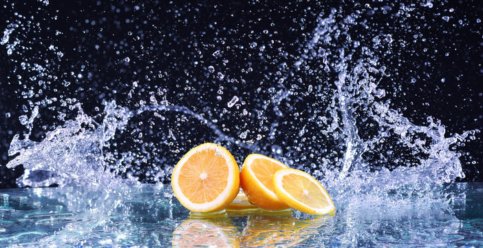 Fototapeta Macro water splash on lemon. Water drops with juicy lemon