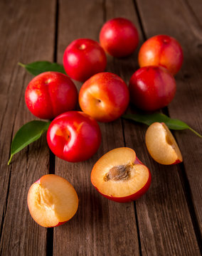 Red plums on wood background