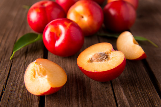 Red plums on wood background
