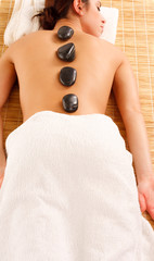 picture of woman in spa salon with hot stones..