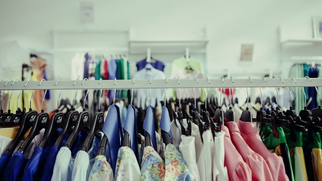 Choice of fashion clothes of different colors on hangers