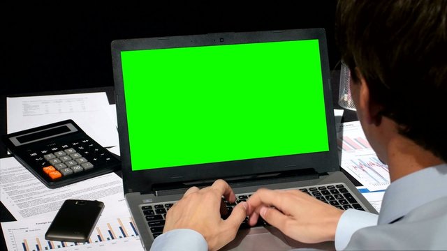 Business people working on his laptop with copy space on a green