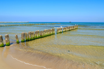 Fototapeta premium Wooden breakwater on beach in Ustka town, Baltic Sea, Poland