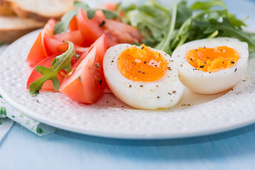 Breakfast with soft-boiled egg, arugula and tomatoes