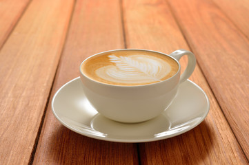A cup of cafe latte on wooden background