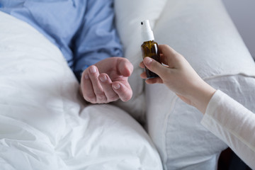 Daughter giving her father medicine