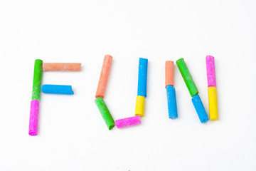 color chalk arranged to spell word FUN