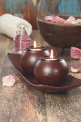 Spa concept with aromatherapy candles and red rose petals