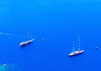 2 big sailing boats under Fira of Santorini island in Greece