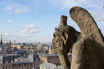 Fototapeta na wymiar Stone gargoyle overlooking Paris from the Notre Dame