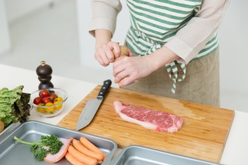 肉を料理中の女性