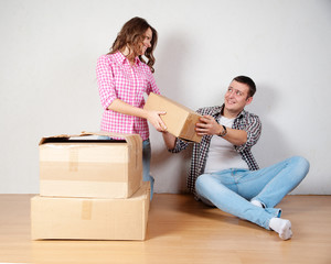 Happy young couple unpacking or packing boxes