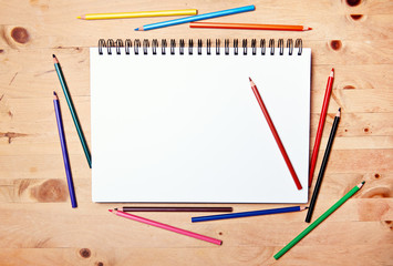 drawing block with copy space on wood table with colored pencil