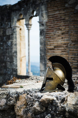 Spartan helmet on castle ruins - obrazy, fototapety, plakaty