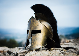 Spartan helmet on rocks. - obrazy, fototapety, plakaty