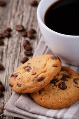 Tasty cookies and coffee cup on a wooden table.