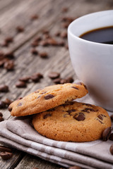 Tasty cookies and coffee cup on a wooden table.