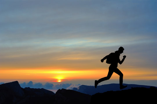 Running jumping man above sunset and mountain. Sport sky © dmitry_dmg