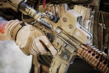 solder in gloves holding assault automatic rifle