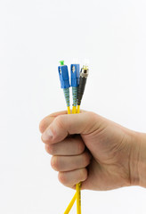 Yellow optic cable with blue patch cord connectors in hand