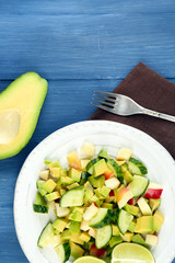 Salad with apple and avocado in bowl on table close up