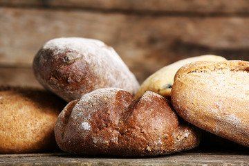 Different fresh bread on old wooden table