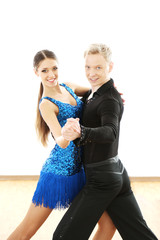 Beautiful couple in active ballroom dance, indoors