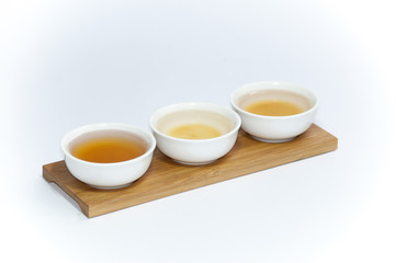 trio of white coffee cups arranged in a row on a wooden tray