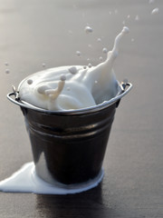 А splash of milk in a bucket.