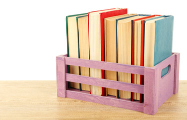 Books in wooden box isolated on white