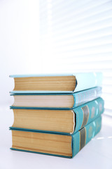 Books on white windowsill, close up