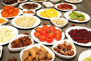 Different products on saucers on wooden table, closeup