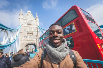 Man taking selfie in London with Tower Bridge on background