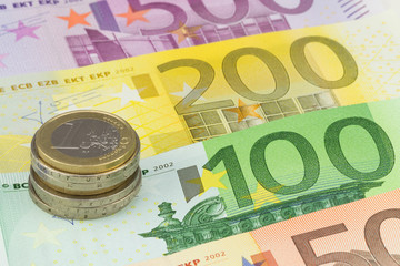 Münzstapel mit verschiedenen Euro Banknoten