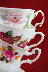 antiques cup and saucer with flower decoration on red background