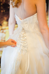 Obraz na płótnie Canvas Helping the bride to put her wedding dress on