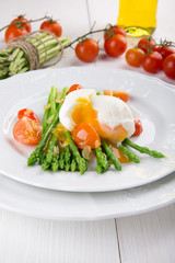 Green asparagus stems with soft-boiled egg, tomato and sauce.