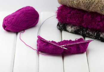 Knitting needles with a ball of woolen threads and sweaters