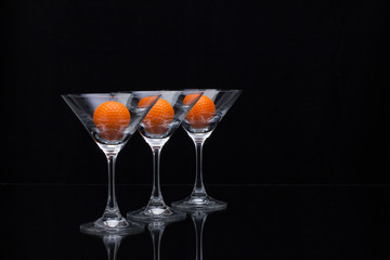 Three glasses of champagne and golf balls